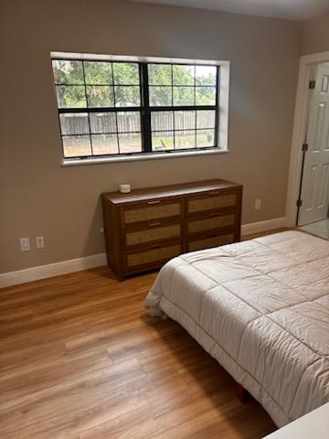 Furnished bedroom with dresser and natural light