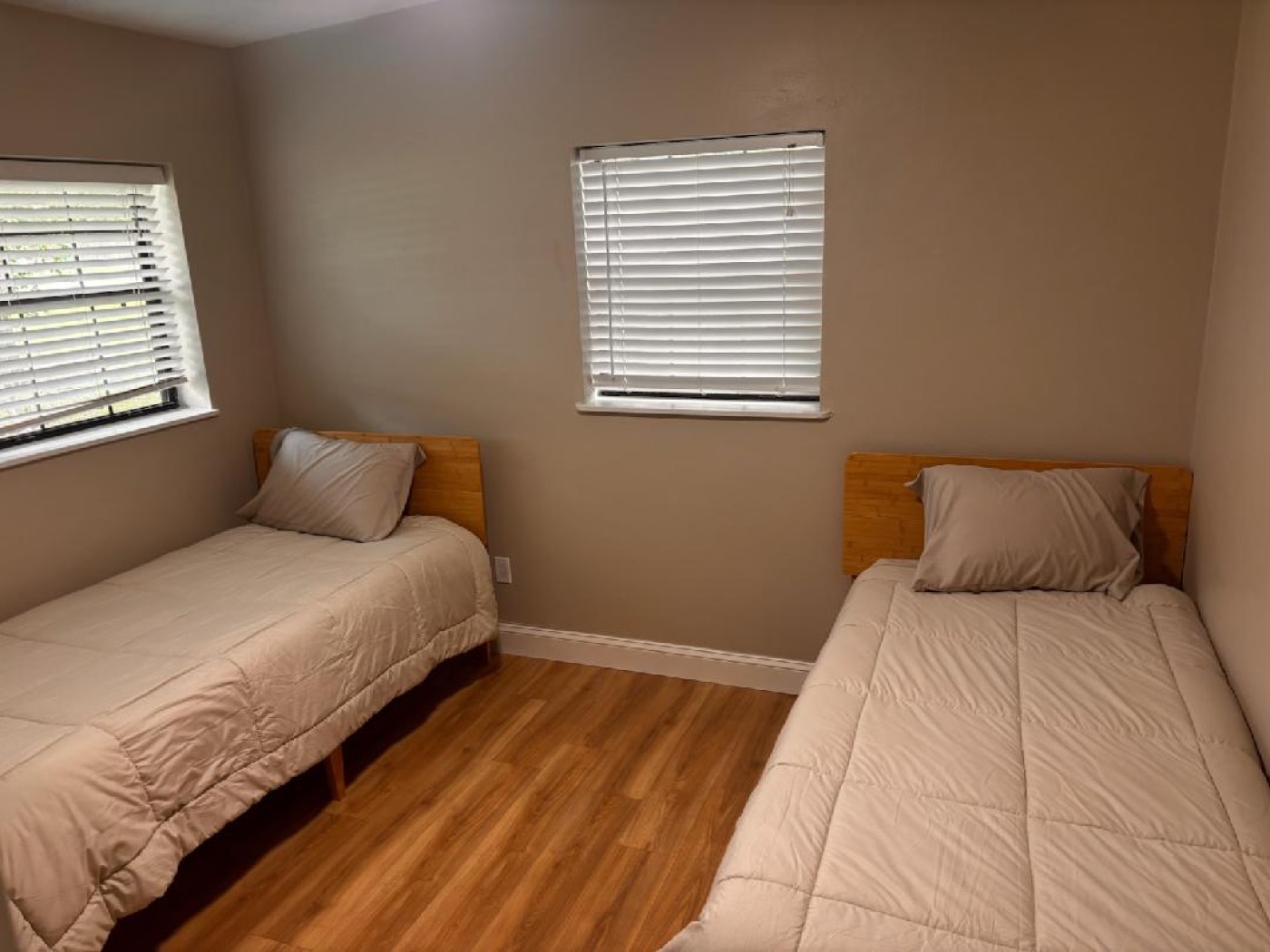 Bedroom with two twin beds, wood headboards and hardwood floor