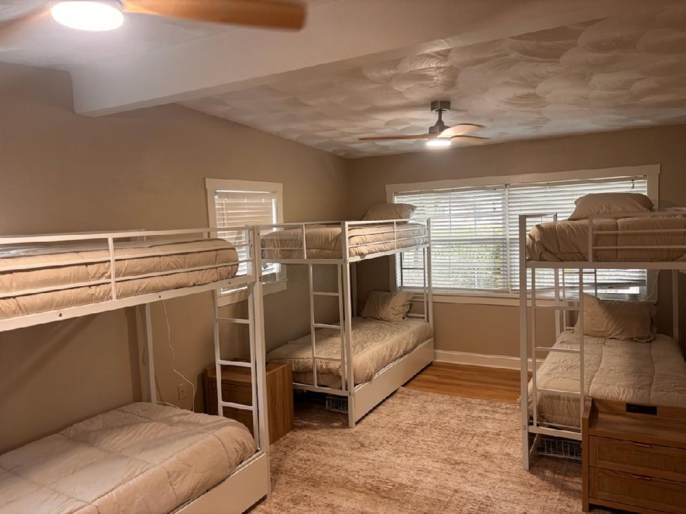 Spacious room with multiple bunk beds and ceiling fans
